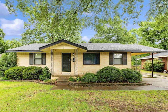 9 Berkshire Dr, Little Rock, AR 72204 - view of front of house featuring an attached carport, a front yard, concrete driveway, brick siding, and roof with shingles