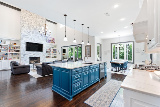 18001 Oak Creek Pl, Little Rock, AR 72223 - kitchen with blue cabinetry, a chandelier, stainless steel appliances, dark wood-style flooring, and white cabinets
