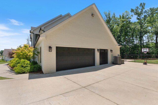 18001 Oak Creek Pl, Little Rock, AR 72223 - view of side of home with concrete driveway, a garage, and brick siding