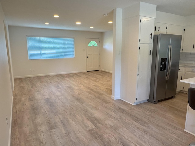 kitchen featuring stainless steel fridge with ice dispenser, recessed lighting, light wood-style flooring, white cabinets, and light countertops