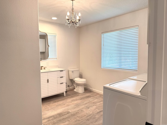 bathroom with separate washer and dryer, vanity, a chandelier, wood finished floors, and recessed lighting