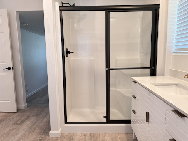 full bath with a stall shower, wood finished floors, and vanity