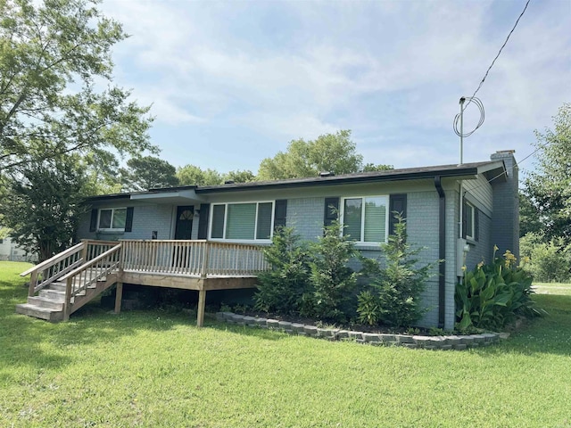 view of front of house featuring a front lawn, a wooden deck, brick siding, and a chimney