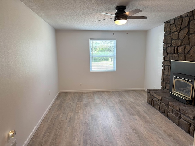 unfurnished living room featuring wood finished floors, ceiling fan, and a textured ceiling