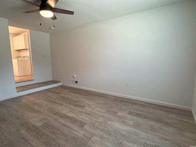 empty room featuring washer / clothes dryer, ceiling fan, wood finished floors, and a textured ceiling