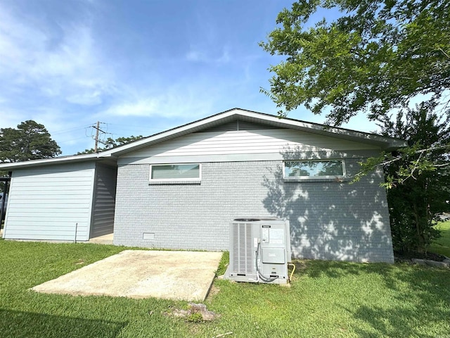 back of property featuring a yard, brick siding, and a patio