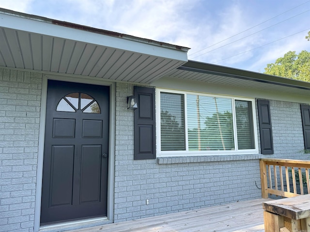view of exterior entry featuring brick siding