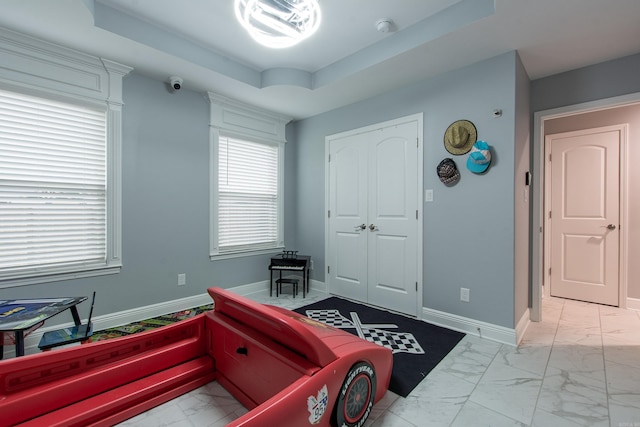 1027 Evening Sunset Cir, Redfield, AR 72132 - bedroom featuring light marble finish flooring, a raised ceiling, and a closet