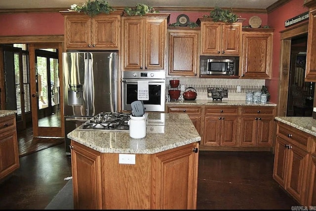 847 Woodland Hills Dr, Mountain View, AR 72560 - kitchen featuring stainless steel appliances, decorative backsplash, ornamental molding, brown cabinetry, and light stone counters