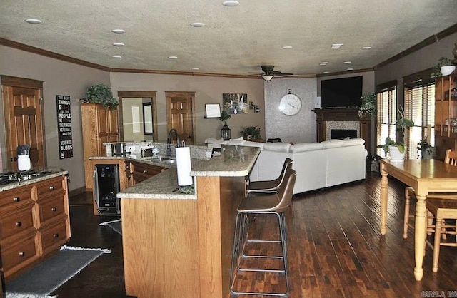 847 Woodland Hills Dr, Mountain View, AR 72560 - kitchen with beverage cooler, ornamental molding, a ceiling fan, dark wood-style floors, and brown cabinetry
