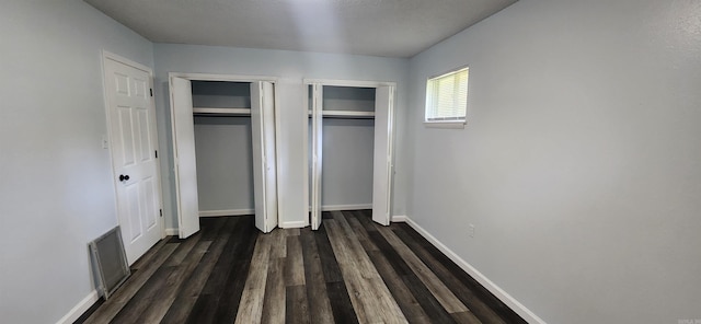 600 Robin Rd, White Hall, AR 71602 - unfurnished bedroom with two closets and dark wood finished floors