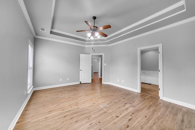 706 Greystone Blvd, Cabot, AR 72023 - unfurnished bedroom with a tray ceiling, crown molding, light wood-style flooring, multiple windows, and ensuite bathroom