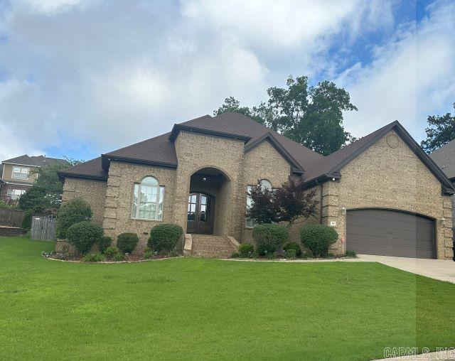 14 Longwell Loop, Little Rock, AR 72211 - french country style house with brick siding, concrete driveway, a front yard, and a garage