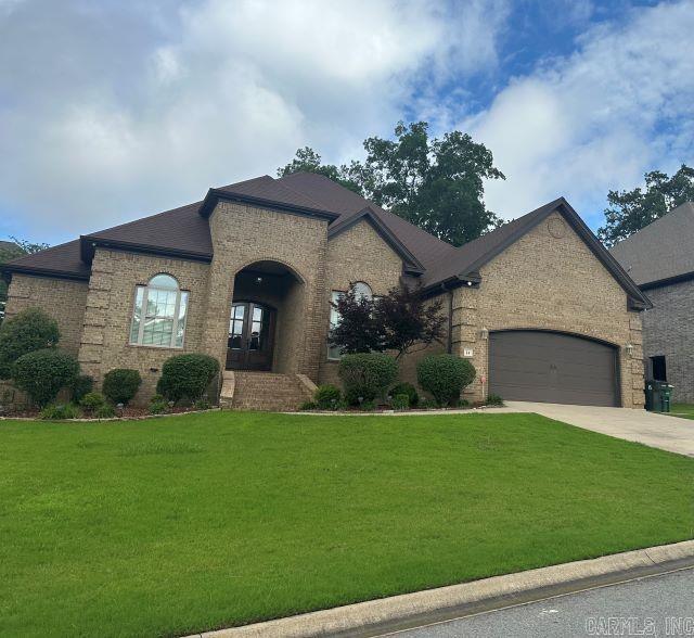 14 Longwell Loop, Little Rock, AR 72211 - french country style house featuring driveway, a front lawn, brick siding, a garage, and french doors