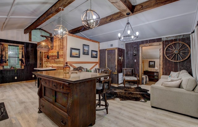 164 Roxie Ln, Greers Ferry, AR 72067 - kitchen featuring a chandelier, wooden walls, light wood-type flooring, a kitchen bar, and pendant lighting