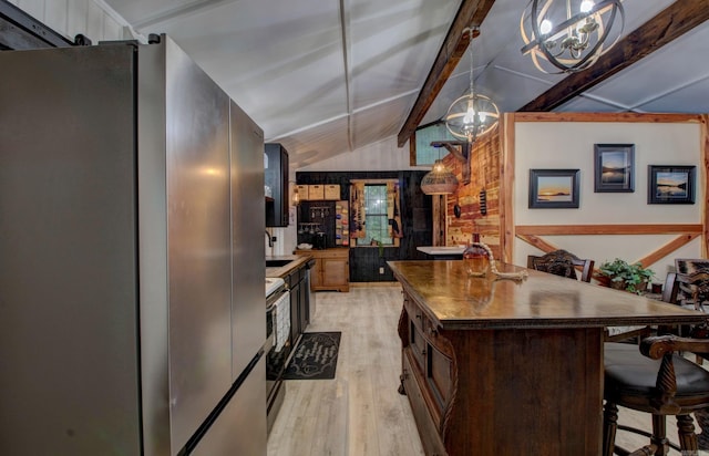 164 Roxie Ln, Greers Ferry, AR 72067 - kitchen with stainless steel appliances, a chandelier, light wood-type flooring, dark countertops, and a kitchen breakfast bar