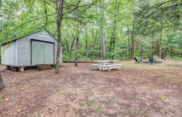 164 Roxie Ln, Greers Ferry, AR 72067 - view of yard featuring a storage shed, a fire pit, and a forest view