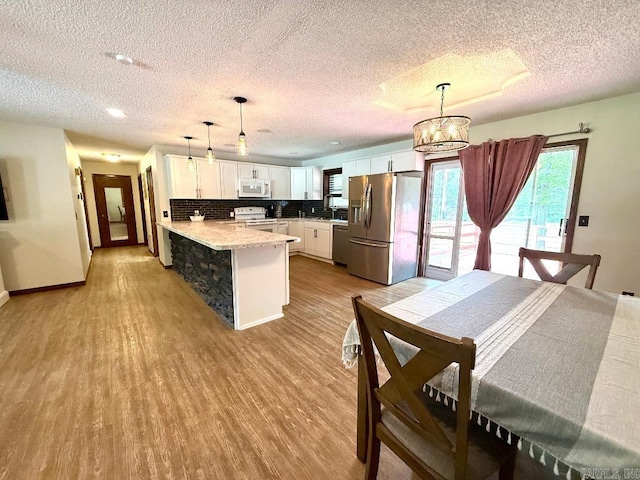 1711 Lonoke Rd, Mountain Home, AR 72653 - dining room with a textured ceiling, light wood-type flooring, and a chandelier