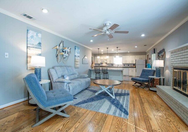 3 Sonata Trl, Little Rock, AR 72205 - living area with hardwood / wood-style flooring, ornamental molding, a ceiling fan, a brick fireplace, and recessed lighting