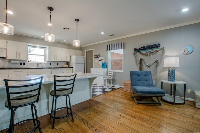 3 Sonata Trl, Little Rock, AR 72205 - kitchen featuring white appliances, decorative backsplash, ornamental molding, white cabinets, and hardwood / wood-style flooring