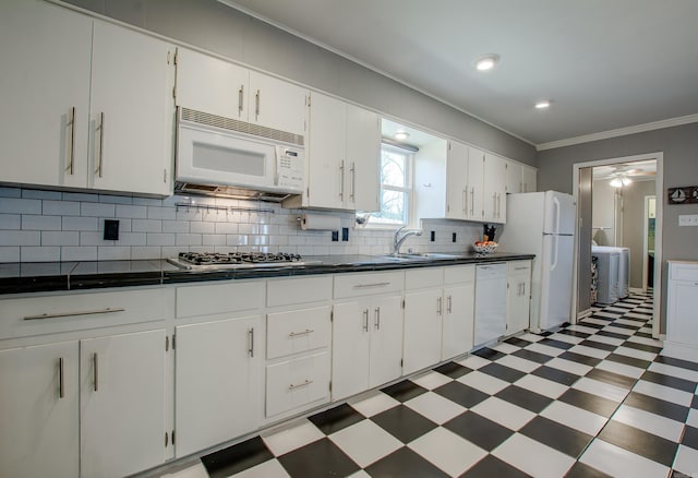 3 Sonata Trl, Little Rock, AR 72205 - kitchen featuring white appliances, light flooring, dark countertops, decorative backsplash, and ornamental molding