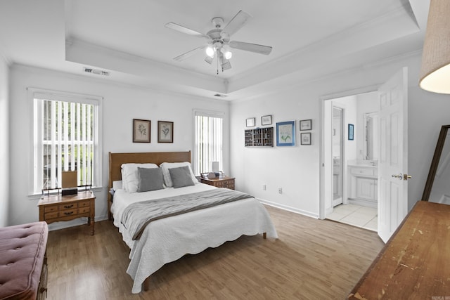 1323 Starfield, North Little Rock, AR 72116 - bedroom featuring a tray ceiling, crown molding, multiple windows, and light wood-style floors