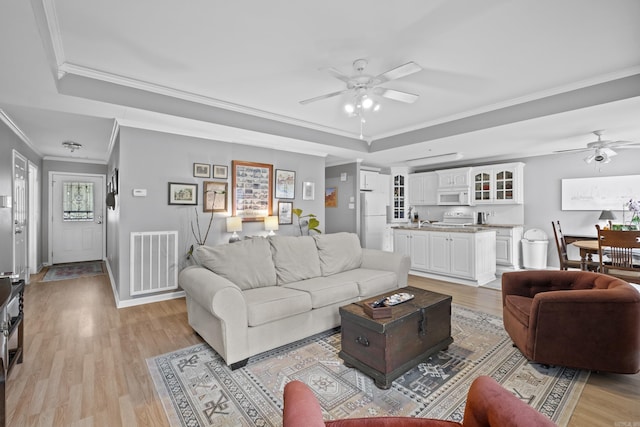 1323 Starfield, North Little Rock, AR 72116 - living area featuring a ceiling fan, a raised ceiling, light wood-style floors, and ornamental molding