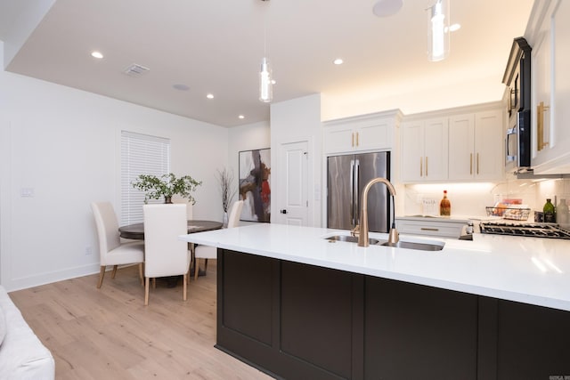 11325 Jamestown Dr, Little Rock, AR 72211 - kitchen with appliances with stainless steel finishes, light wood-style flooring, a peninsula, light countertops, and pendant lighting