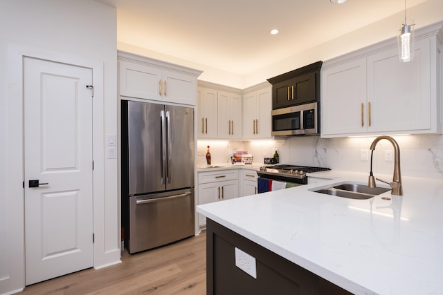 11325 Jamestown Dr, Little Rock, AR 72211 - kitchen with appliances with stainless steel finishes, tasteful backsplash, light wood-style flooring, decorative light fixtures, and recessed lighting