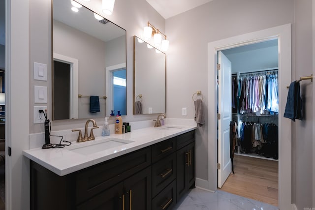 11325 Jamestown Dr, Little Rock, AR 72211 - full bathroom featuring double vanity, a walk in closet, marble look tile flooring, and plenty of natural light