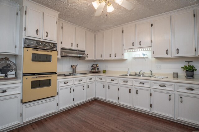 3209 Jack Mann Rd, Little Rock, AR 72210 - kitchen with white appliances, under cabinet range hood, white cabinets, light countertops, and a textured ceiling