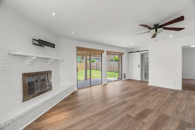 125 Englewood Rd, Little Rock, AR 72207 - unfurnished living room featuring ceiling fan, wood finished floors, recessed lighting, a fireplace, and a barn door