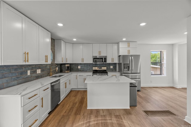 125 Englewood Rd, Little Rock, AR 72207 - kitchen with stainless steel appliances, light wood-type flooring, backsplash, white cabinets, and recessed lighting