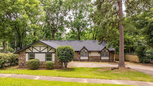 8719 Evergreen Dr, Little Rock, AR 72227 - tudor-style house featuring stone siding and view of wooded area