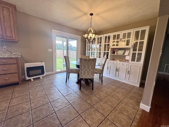 389 Plantation Cir, Melbourne, AR 72556 - dining space featuring heating unit, a chandelier, and a textured ceiling