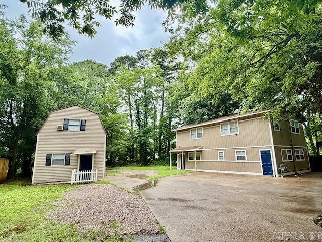 1520 S Main St, Malvern, AR 72104 - back of property featuring view of scattered trees and an outbuilding
