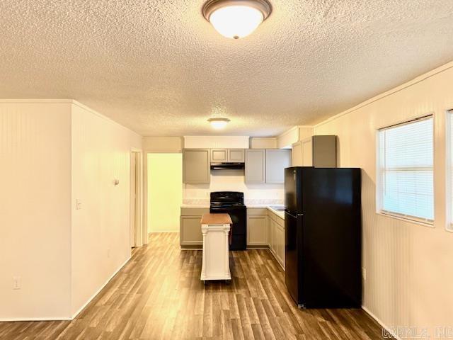 1520 S Main St, Malvern, AR 72104 - kitchen featuring freestanding refrigerator, range, wood finished floors, a textured ceiling, and a center island