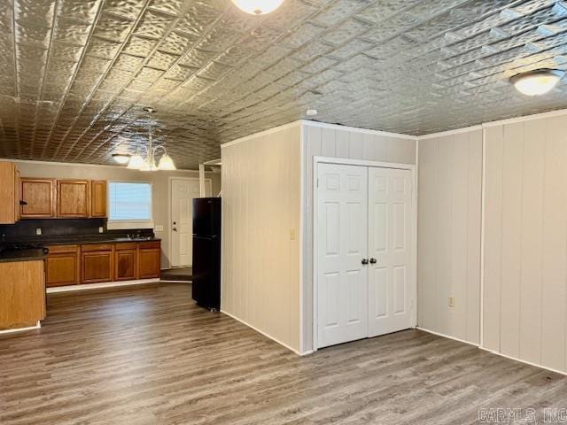 1520 S Main St, Malvern, AR 72104 - kitchen with freestanding refrigerator, dark countertops, an ornate ceiling, dark wood-style flooring, and brown cabinets