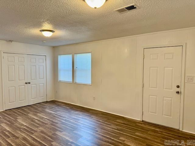 1520 S Main St, Malvern, AR 72104 - unfurnished bedroom with a textured ceiling, dark wood-style floors, and a closet