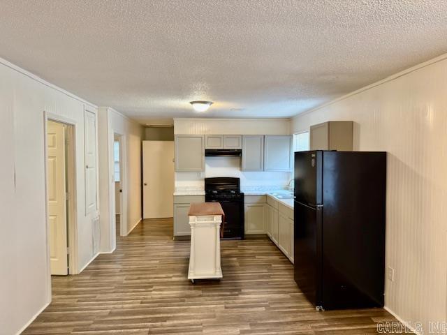 1520 S Main St, Malvern, AR 72104 - kitchen featuring black appliances, ornamental molding, wood finished floors, a textured ceiling, and a kitchen island