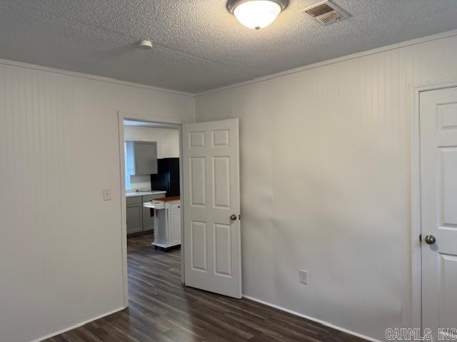 1520 S Main St, Malvern, AR 72104 - unfurnished room with dark wood finished floors, crown molding, and a textured ceiling