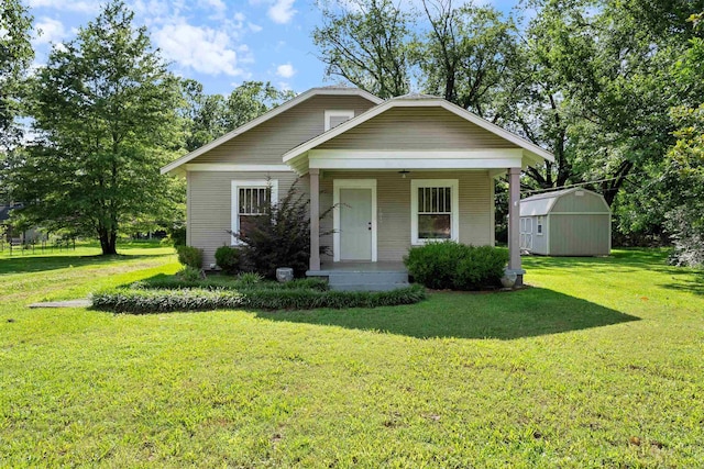 1017 Watkins St, Conway, AR 72034 - view of front of house with covered porch, a storage unit, and a front lawn