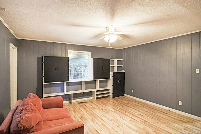 42 Bradford, Little Rock, AR 72227 - living room with a textured ceiling, ornamental molding, a ceiling fan, wood finished floors, and wood walls