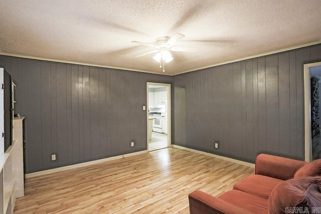 42 Bradford, Little Rock, AR 72227 - living area featuring a ceiling fan, wood finished floors, a textured ceiling, wooden walls, and ornamental molding