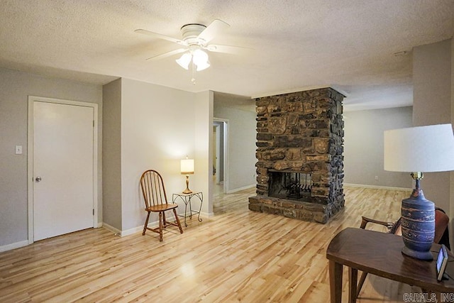 42 Bradford, Little Rock, AR 72227 - living area with ceiling fan, wood finished floors, a textured ceiling, and a stone fireplace