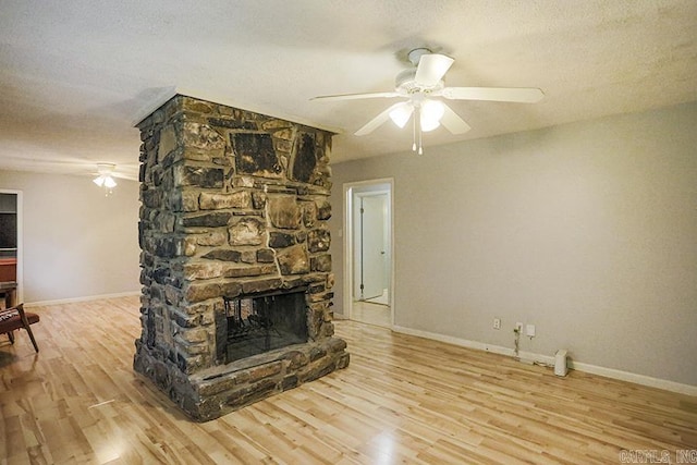 42 Bradford, Little Rock, AR 72227 - unfurnished living room featuring a ceiling fan, wood finished floors, a textured ceiling, and a fireplace