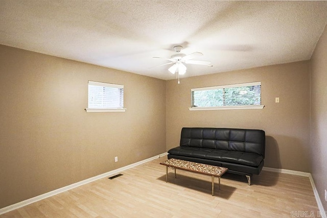 42 Bradford, Little Rock, AR 72227 - living area featuring light wood finished floors, ceiling fan, and a textured ceiling