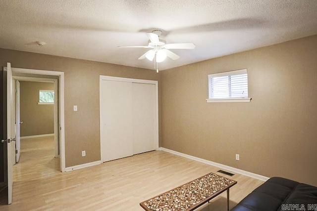 42 Bradford, Little Rock, AR 72227 - unfurnished bedroom with light wood-type flooring, multiple windows, a closet, ceiling fan, and a textured ceiling