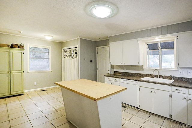 42 Bradford, Little Rock, AR 72227 - kitchen with dishwasher, light tile patterned flooring, a center island, crown molding, and white cabinets