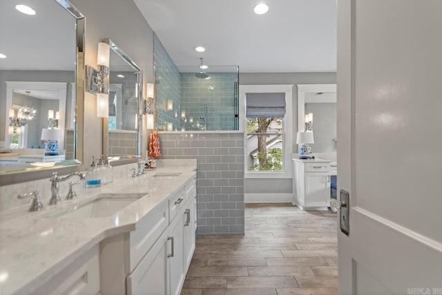 1116 Kavanaugh Blvd, Little Rock, AR 72205 - bathroom with double vanity, a tile shower, wood tiled floors, and recessed lighting